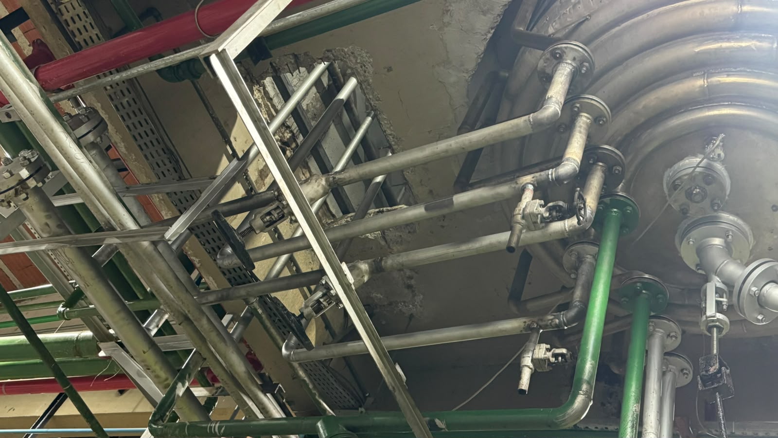 Montagem de tubulação industrial com suportes metálicos em planta fabril