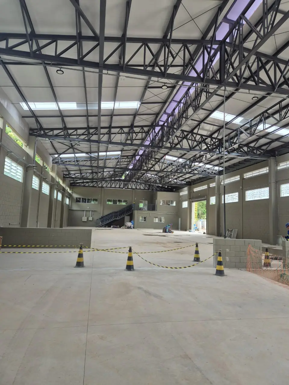 Galpão industrial com estrutura metálica treliçada em montagem